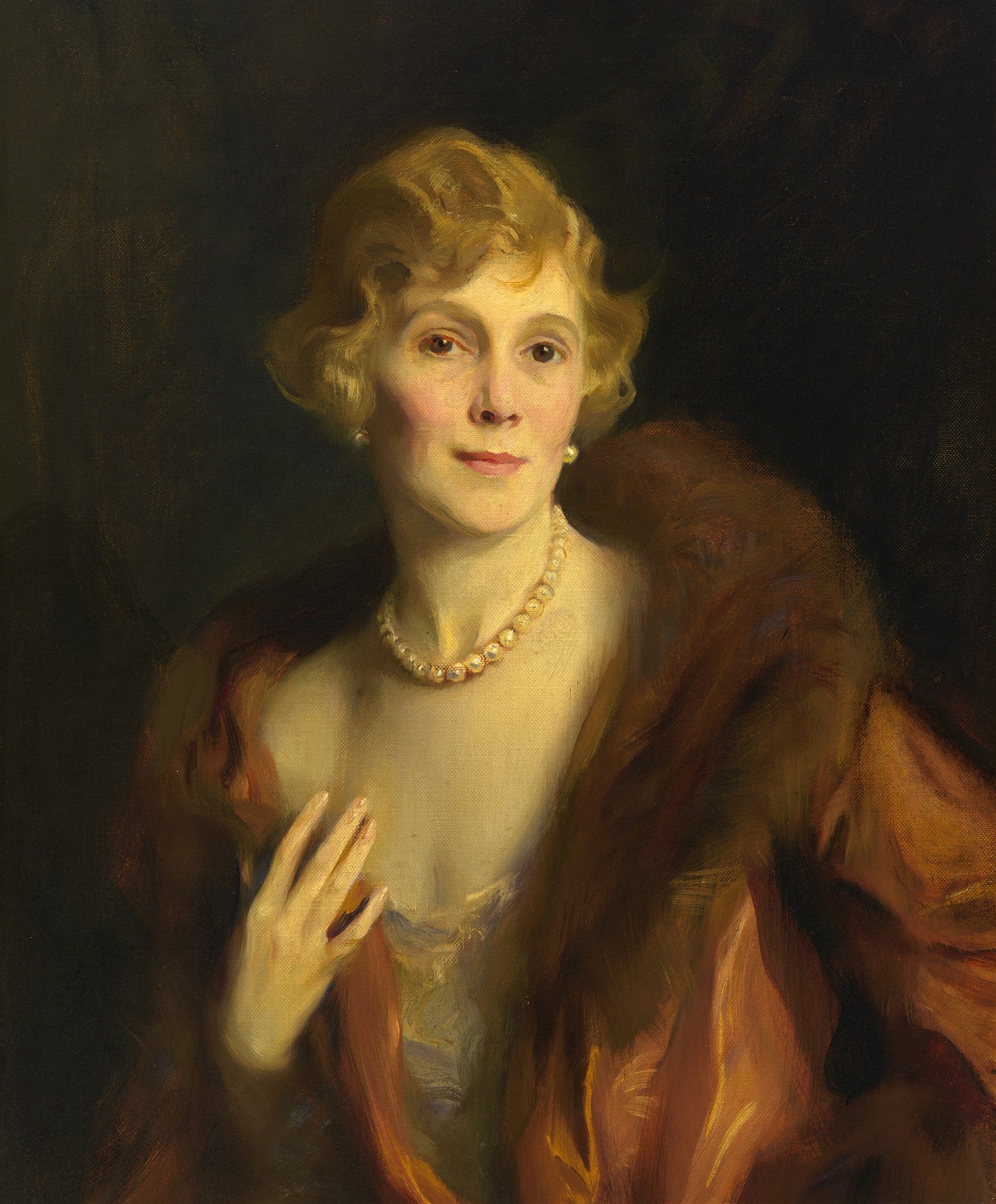 Retrato a óleo de uma mulher de meia-idade com cabelos loiros curtos, colar de pérolas e um casaco de pele marrom-avermelhado. O fundo é escuro, e a luz incide sobre seu rosto e colo. A obra é atribuída a Philip Alexius de László.