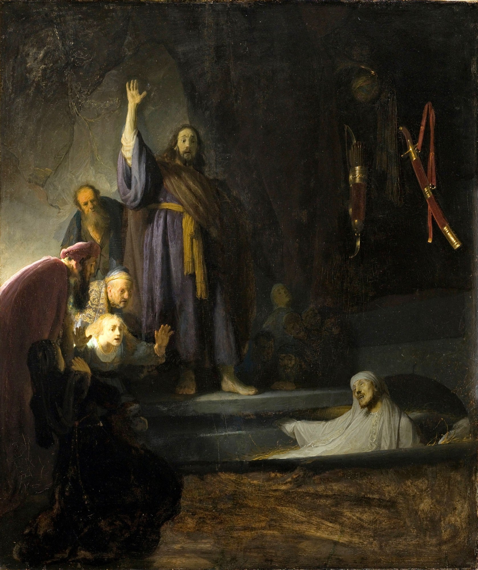 Quadro decorativo "A Ressurreição de Lázaro" de Rembrandt, mostrando Jesus com a mão levantada, Lázaro saindo do túmulo e figuras ao redor com expressões de surpresa e reverência.