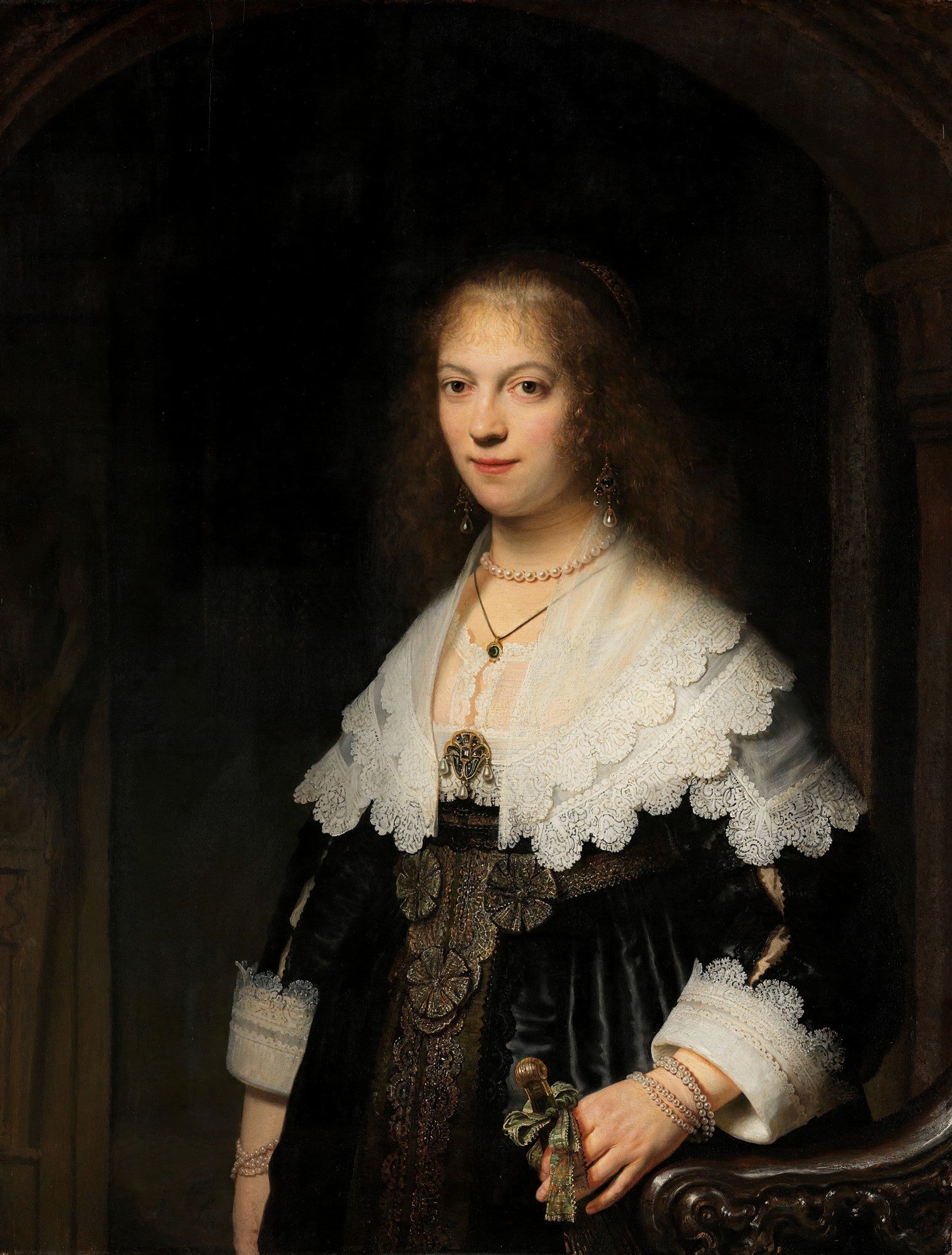 Retrato de uma jovem mulher com colar de pérolas, vestindo roupas de época escuras com detalhes em renda branca, pintado por Rembrandt. Iluminação dramática realça o rosto.