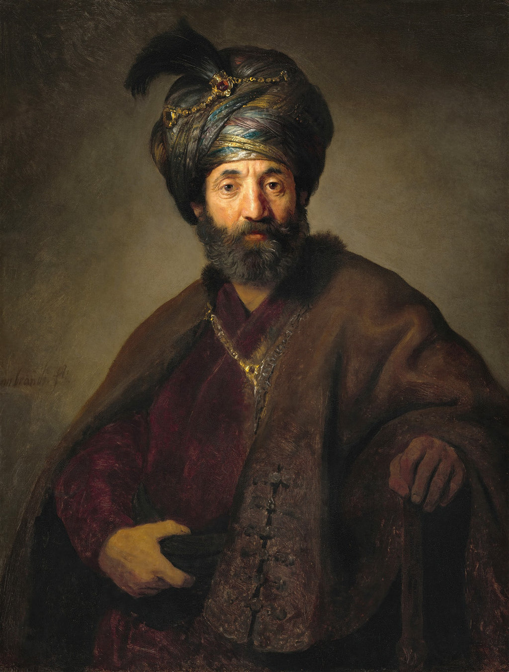 Retrato de um homem barbudo com um turbante ricamente decorado e um manto escuro, atribuído a Rembrandt van Rijn. O homem tem uma expressão pensativa e veste joias douradas. A iluminação dramática destaca seu rosto.