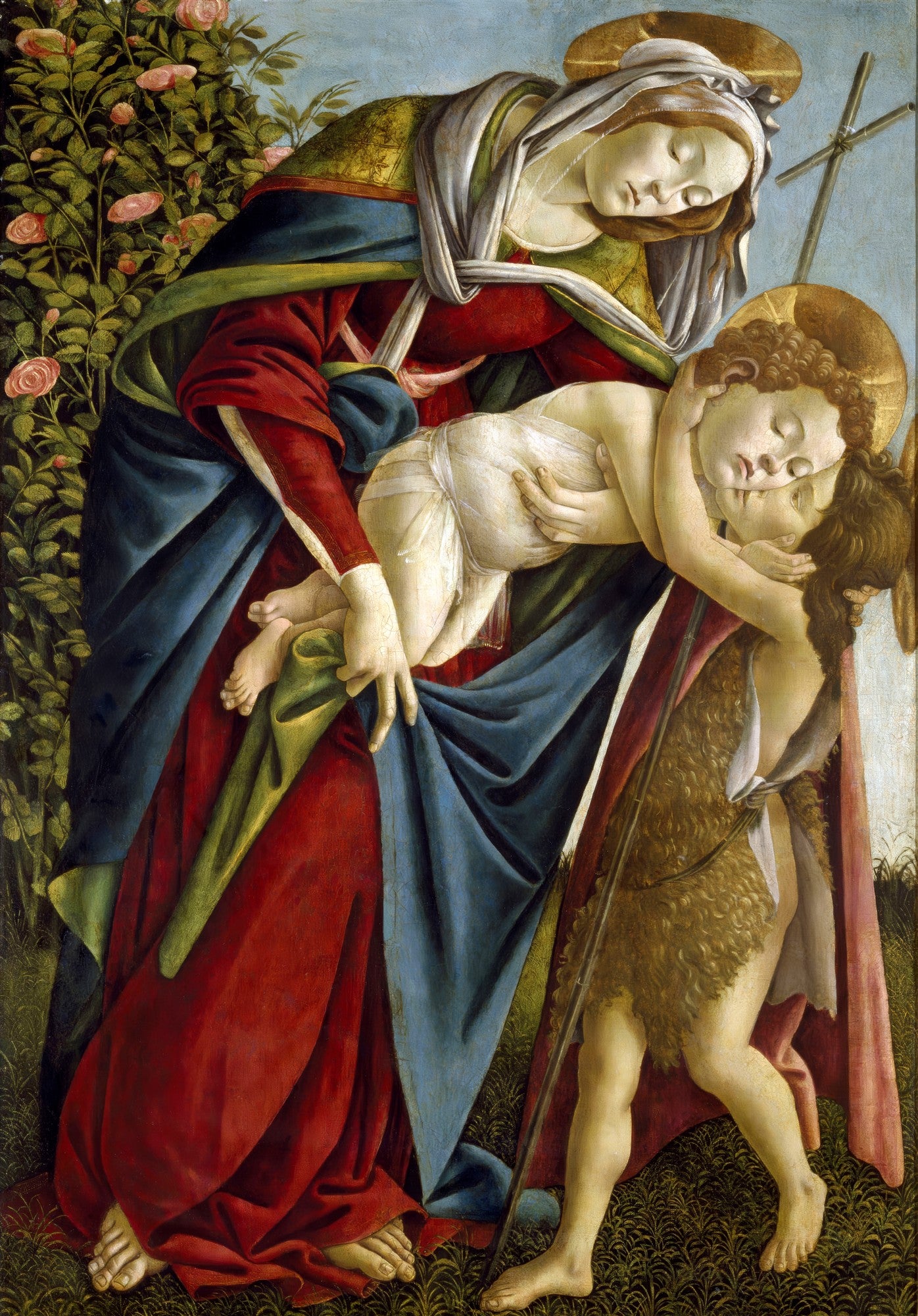 Quadro 'A Virgem e o Menino com São João Batista' de Sandro Botticelli. A Virgem Maria, com vestes vermelhas e azuis, segura o Menino Jesus que abraça São João Batista. Ao fundo, um roseiral e uma cruz.