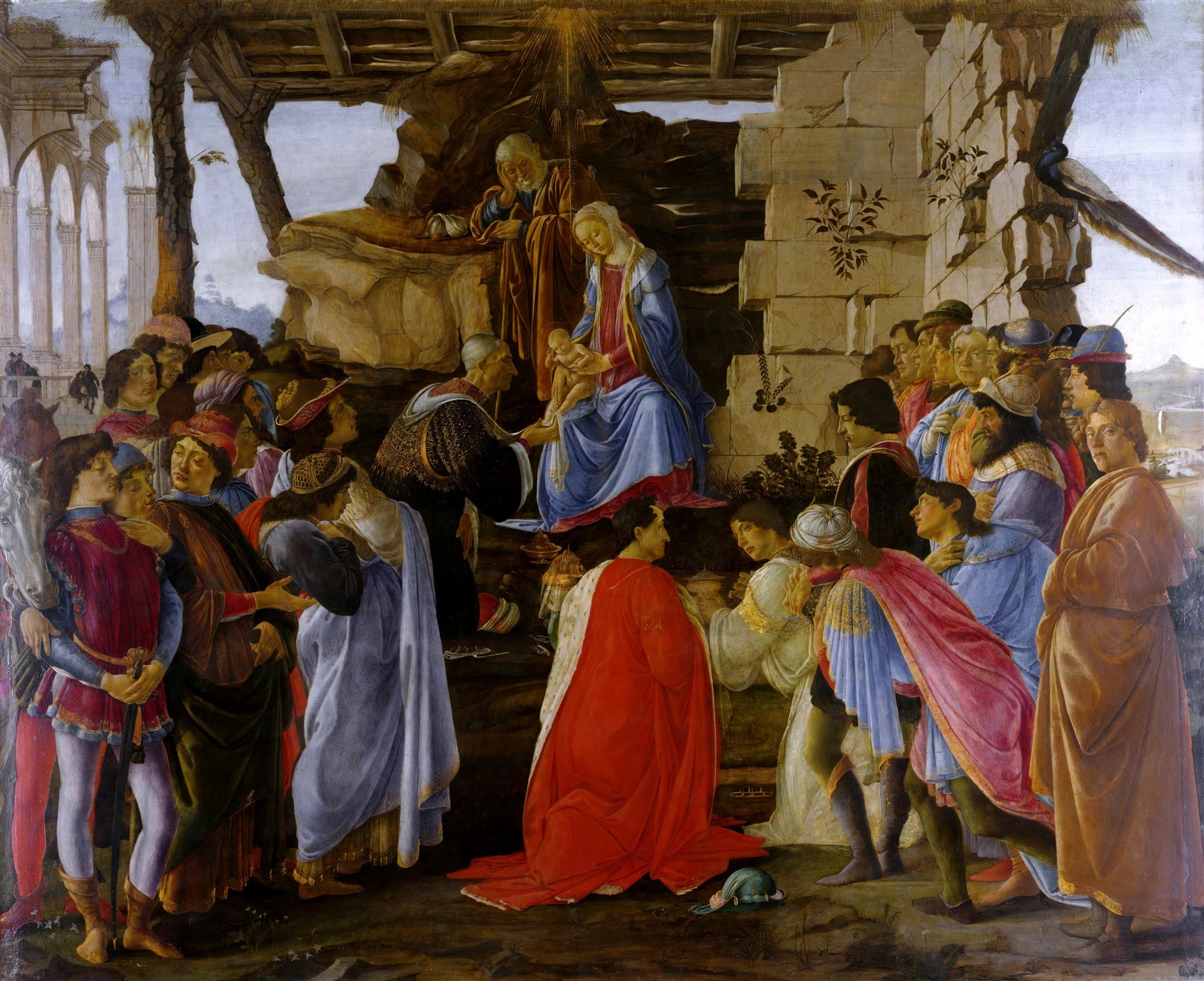 Pintura a óleo de Sandro Botticelli, 'A Adoração dos Magos', mostrando a Virgem Maria e o Menino Jesus cercados por uma multidão de figuras ricamente vestidas, incluindo os Três Reis Magos, em um cenário de ruínas arquitetônicas.