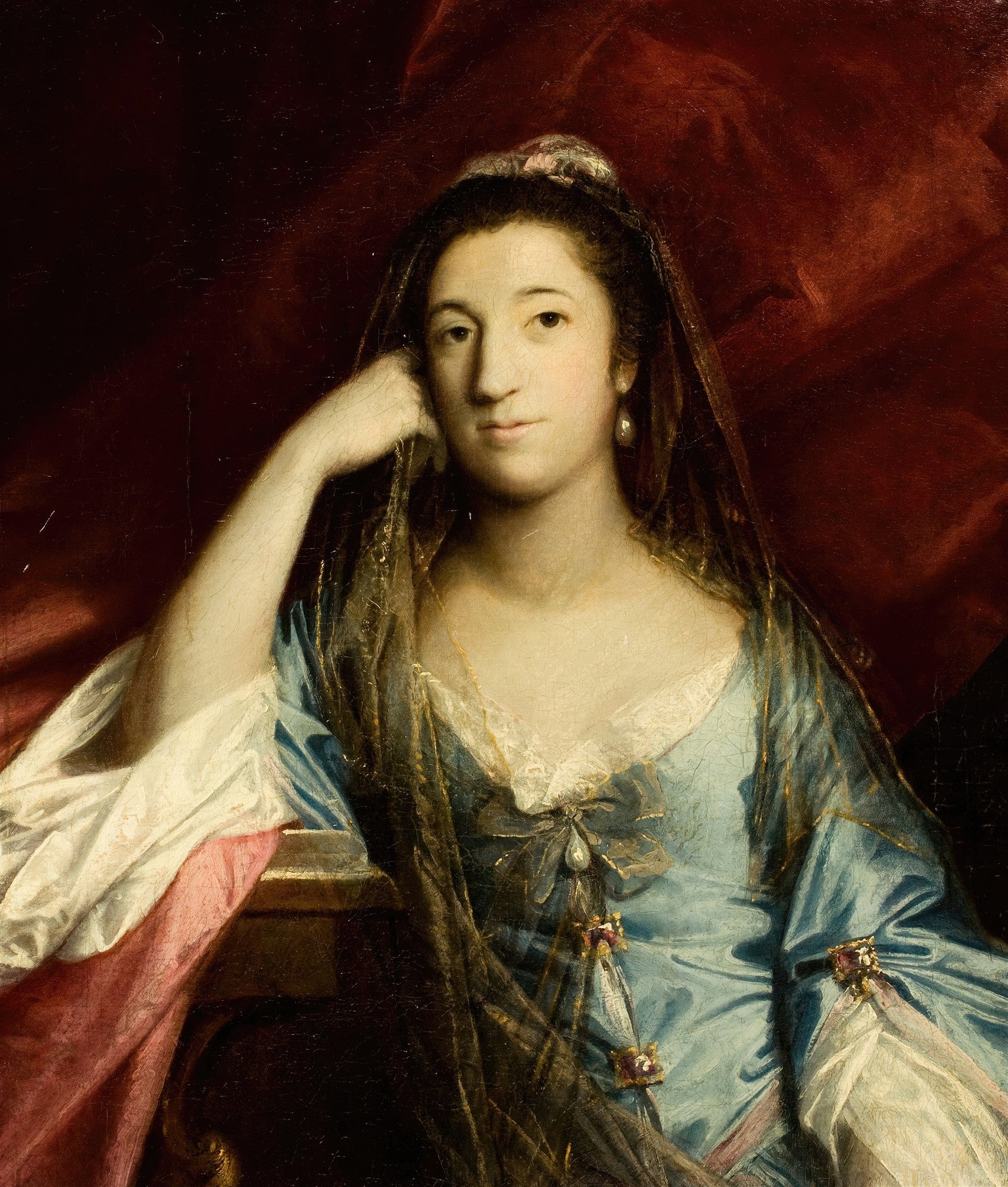 Retrato de uma senhora do século XVIII, atribuído a Sir Joshua Reynolds, vestindo um vestido azul com renda e um véu escuro, com um fundo vermelho amarronzado. A mulher tem um olhar direto e expressivo, com a mão apoiada no rosto.
