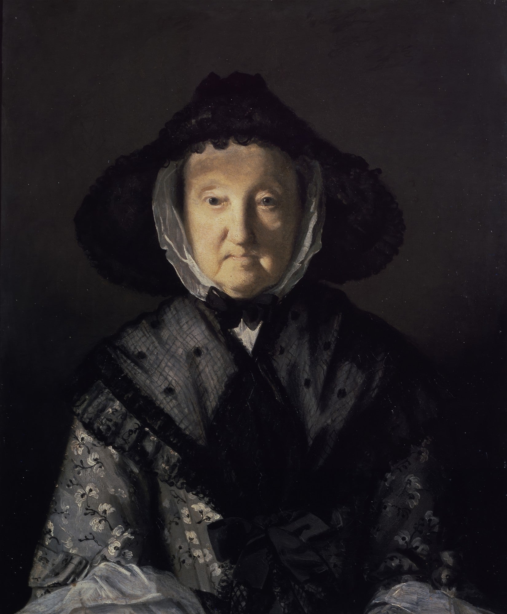 Retrato de mulher idosa vestindo um chapéu e roupas escuras, com rosto iluminado e fundo escuro. Atribuído a Sir Joshua Reynolds.