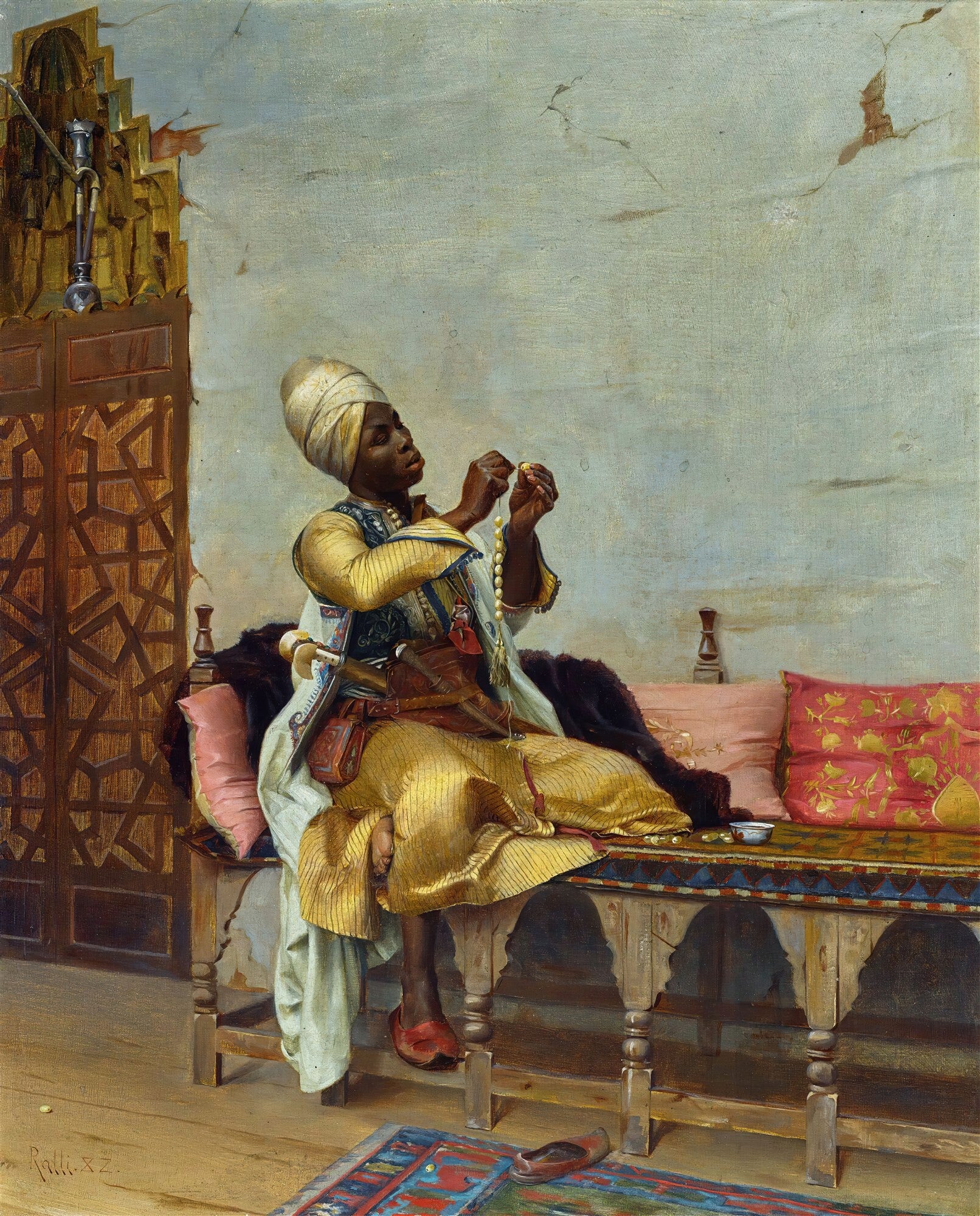 Quadro decorativo mostrando um homem de pele escura com turbante branco e roupas douradas e brancas, sentado em um banco de madeira, confeccionando um rosário. À sua esquerda, um narguilé. Ao fundo, parede e porta com treliça marroquina. Obra de Theodoros Ralli.