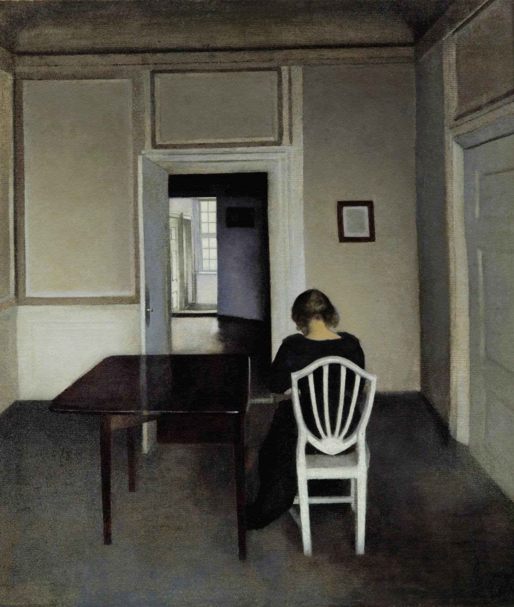 Quadro decorativo Interior com Mulher Sentada, de Vilhelm Hammershøi, mostrando uma mulher de costas em um interior melancólico, com uma mesa e uma porta ao fundo. A imagem tem tons neutros e iluminação suave.