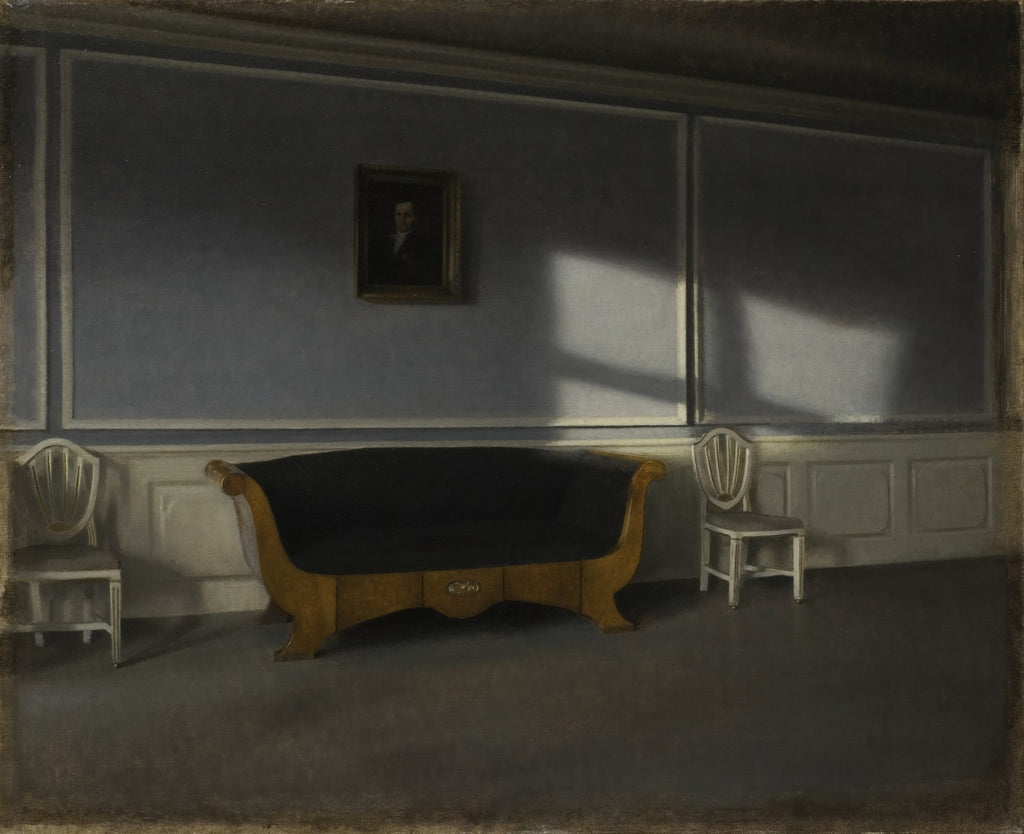 Quadro decorativo mostrando um interior escuro e silencioso de Vilhelm Hammershøi, com um sofá antigo de madeira e estofamento escuro no centro, duas cadeiras laterais brancas, um retrato na parede azul-acinzentada e raios de sol entrando por uma janela invisível, criando padrões de luz e sombra no chão e na parede.