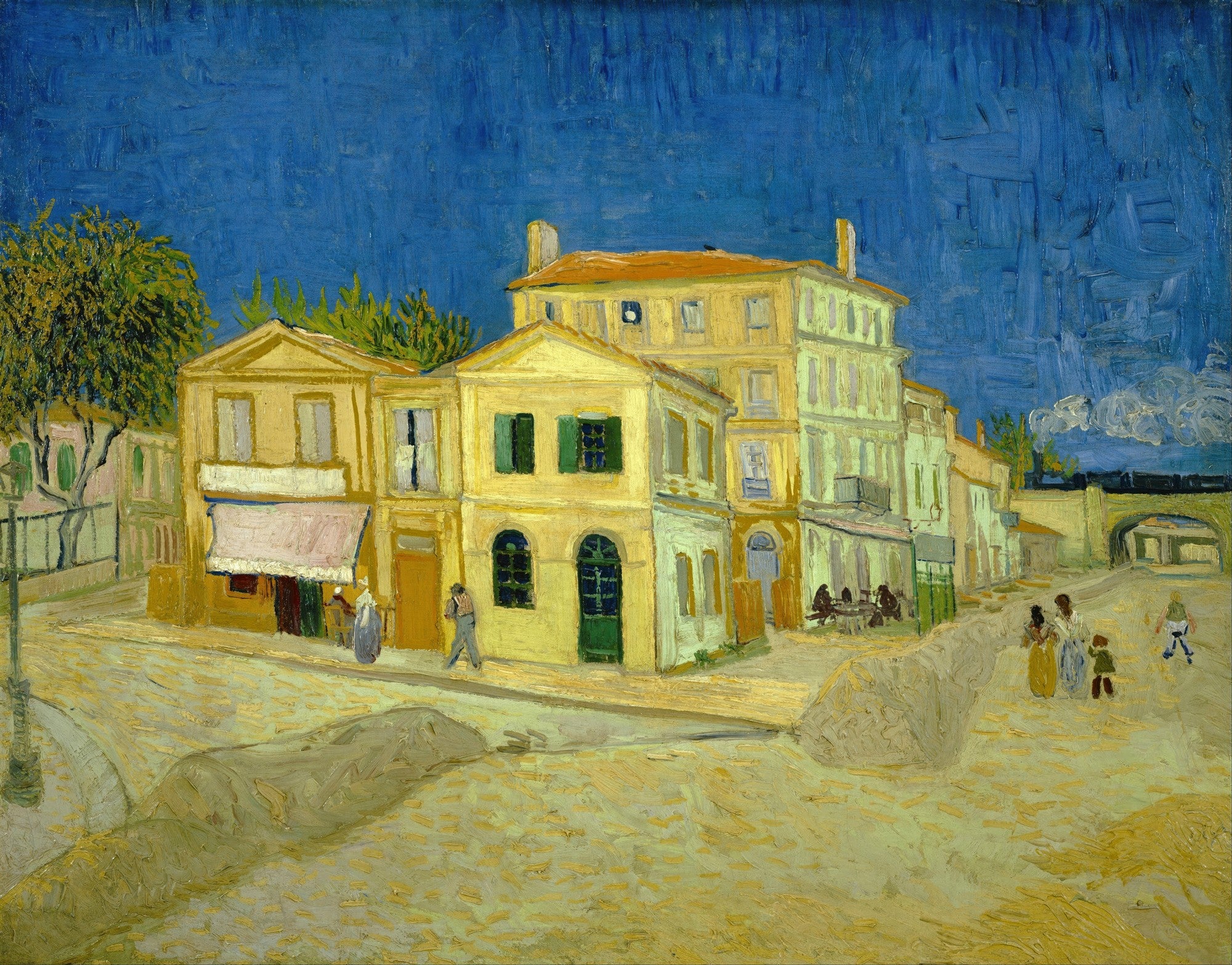 Quadro decorativo 'A Casa Amarela' de Vincent van Gogh, mostrando edifícios amarelos sob um céu azul intenso, com figuras na rua.